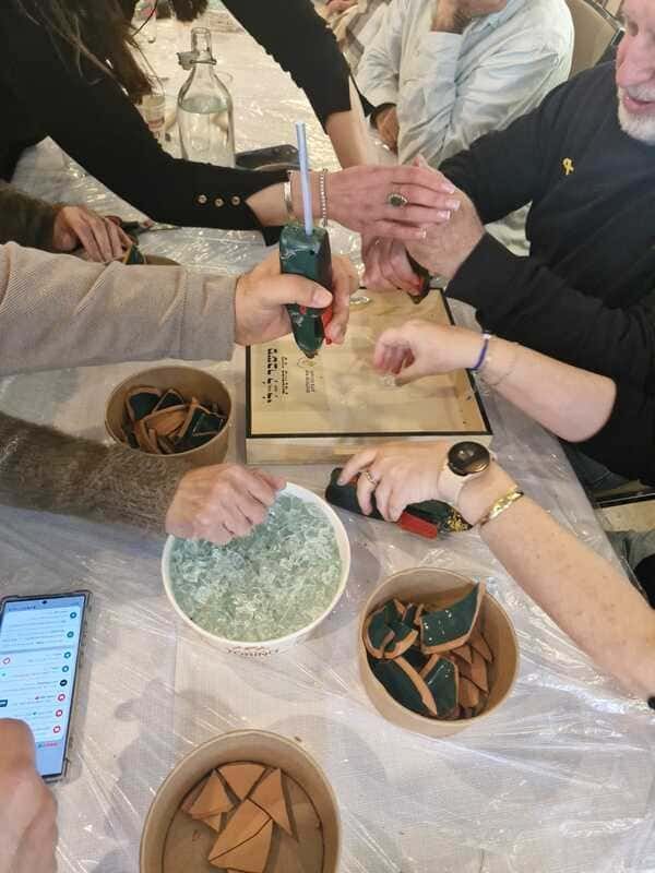 ערכת משבר לכלי יחודית המכילה כלי חרס לשבירה ובנייה מחדש ושברי זכוכית - משתתפים לוקחים חלק בסדנא